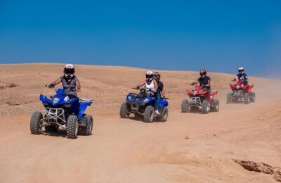 Quad biker navigating through the Agafay Desert, surrounded by rocky terrain and scenic landscapes.