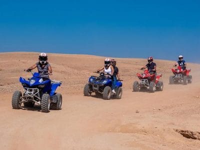 Quad biker navigating through the Agafay Desert, surrounded by rocky terrain and scenic landscapes.