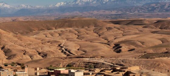 Wide-angle view of the Agafay Desert with distant Atlas Mountains